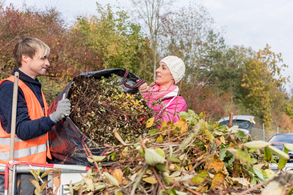 HWRC operative helping resident dispose of garden waste at hwrc site